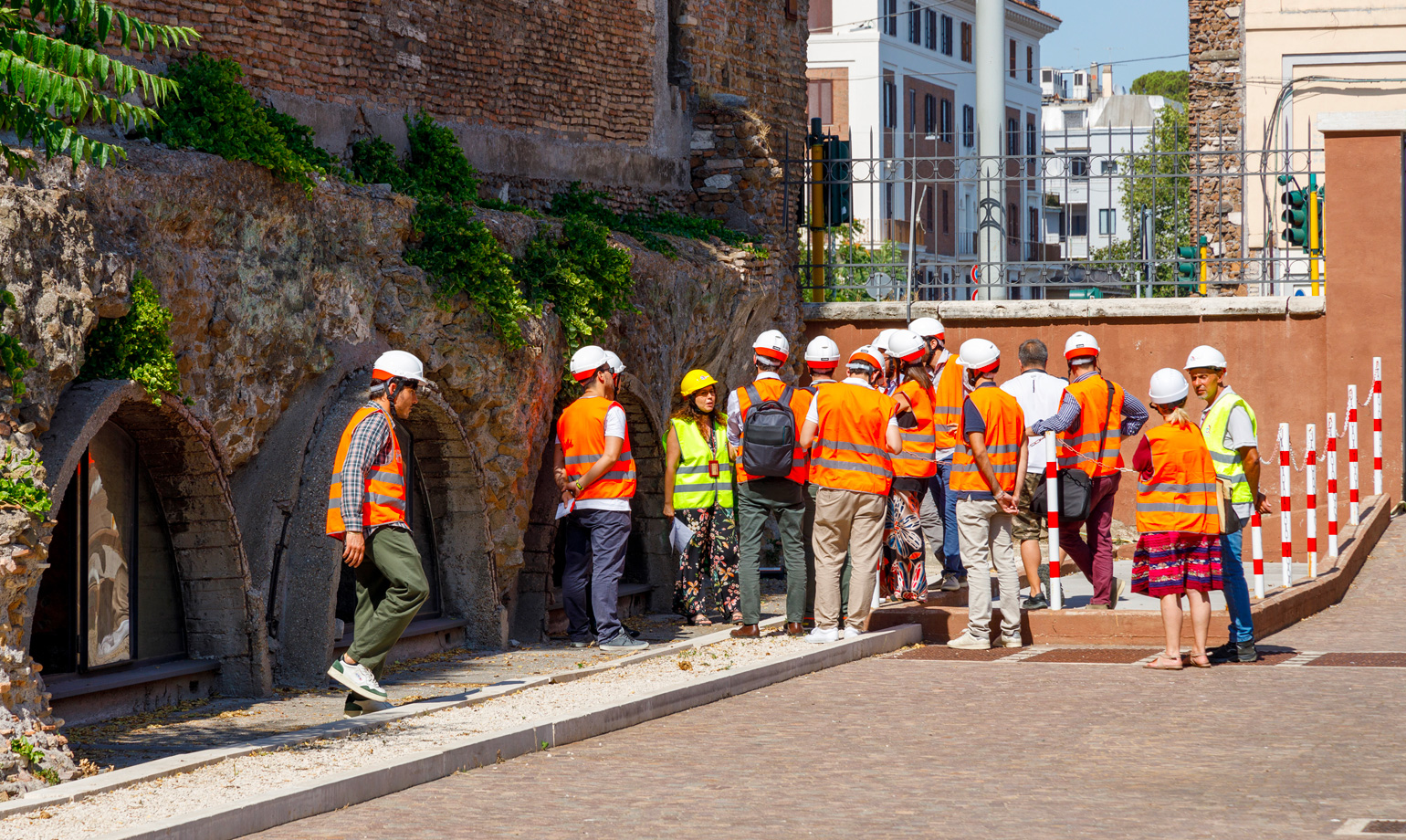 Gruppo di persone con caschi e giubbotti riflettenti in visita tecnica